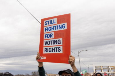 A sign which reads "Still Fighting for Voting Rights"