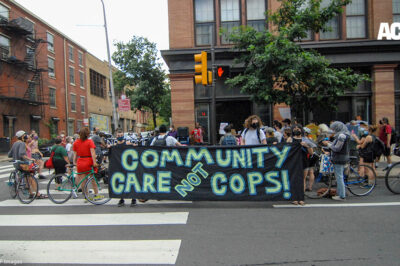 Protesters hold a banner calling for investment in communities, not the police